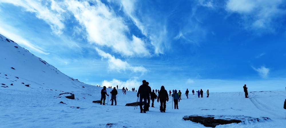Ruinsara Tal Trek alpine lake surrounded by snow-capped Himalayan peaks 