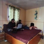 • Budget stay Sankri — exterior view of Himalaya Trek Inn with Himalayan ridgeline in background